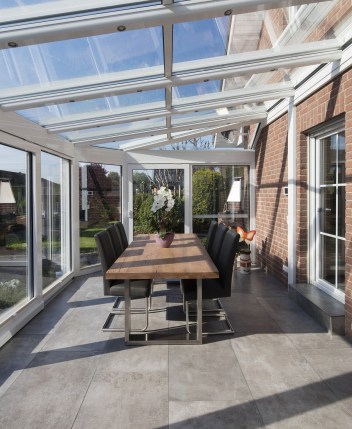 Carrelage rectangle gris chaud dans une véranda blanche avec de la brique